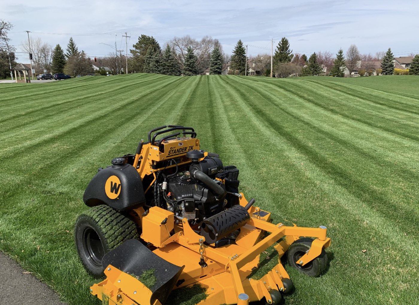 Greener Results mower on a wide striped lawn
